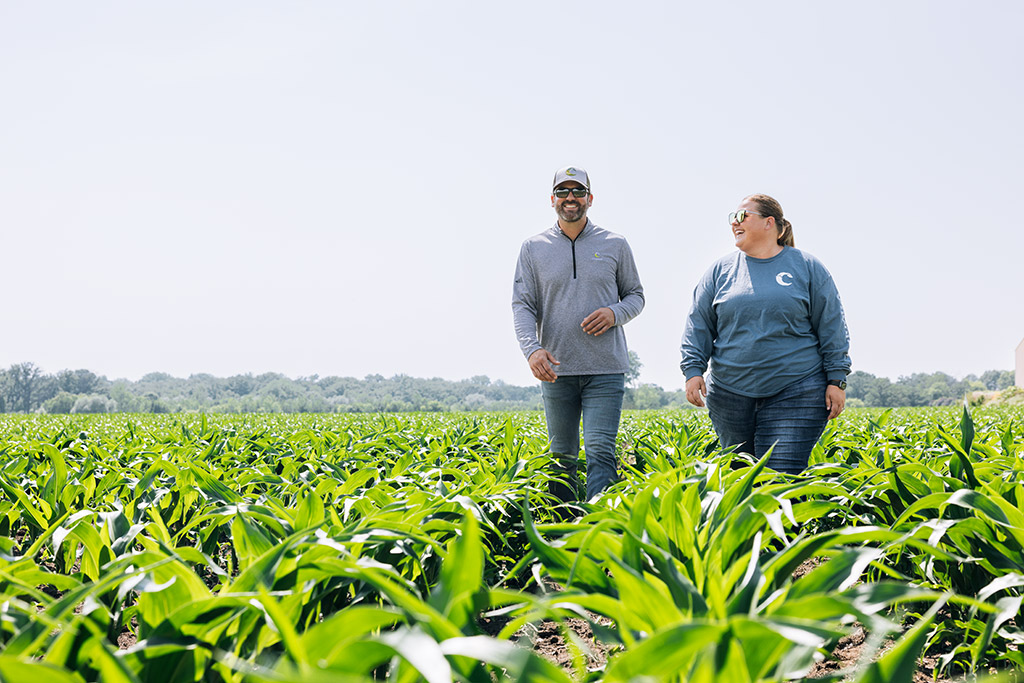 Two people walking through a field, laughing.