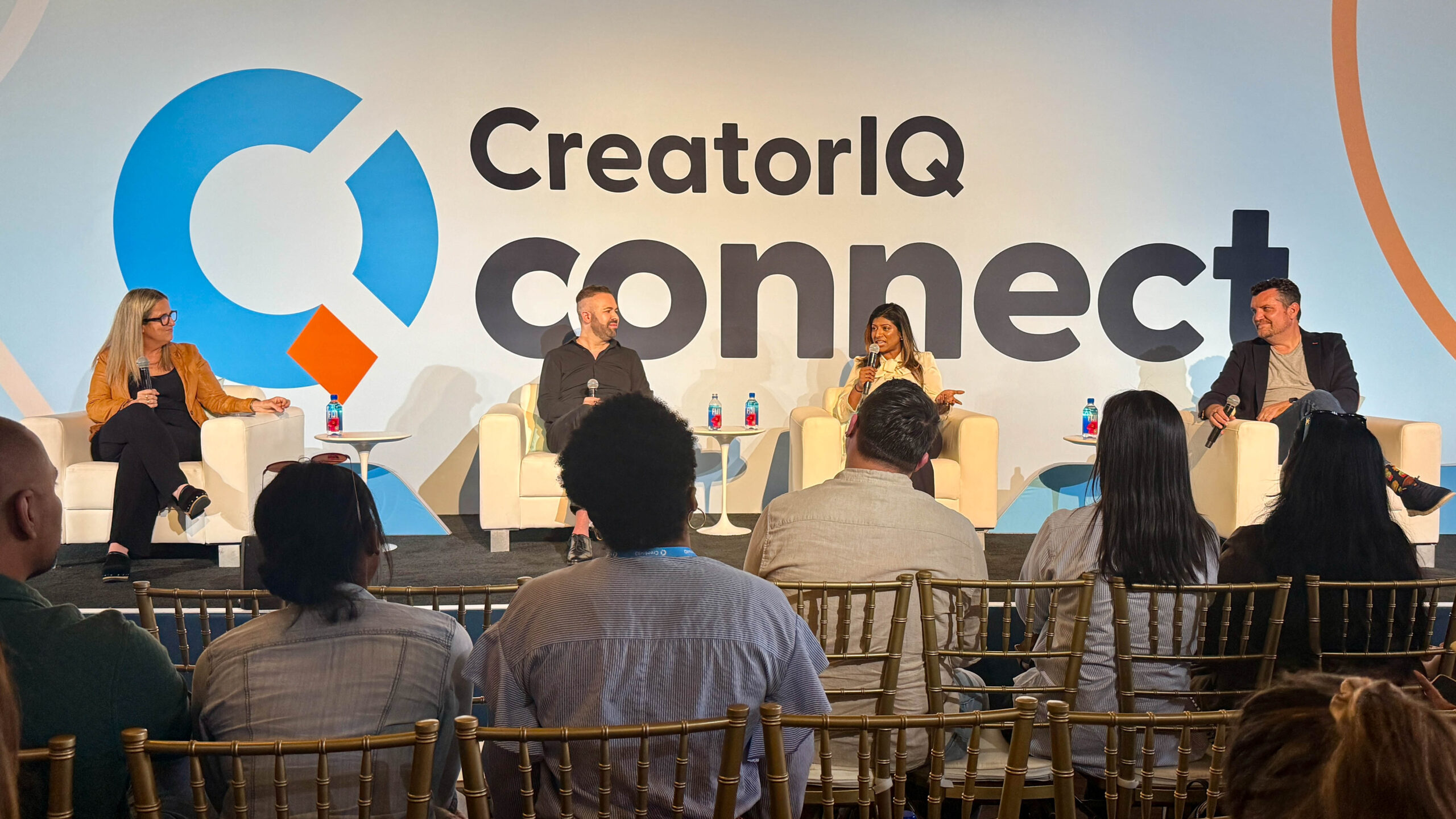 A crowd point of view of 4 speakers presenting on stage at CreatorIQ Connect.