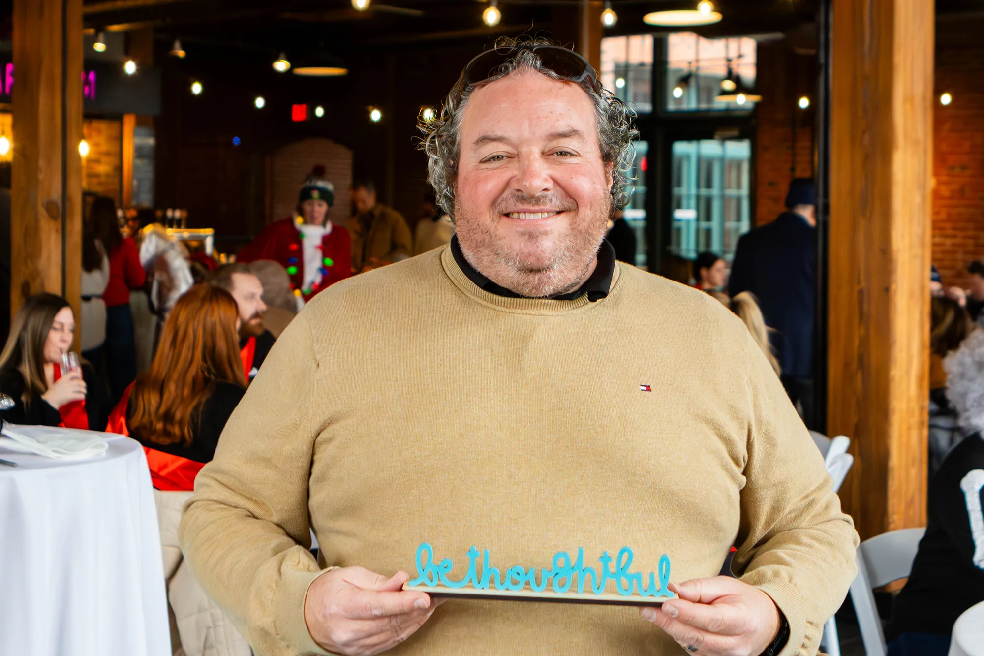 Matt Anselm holding the "Be Thoughtful" award.